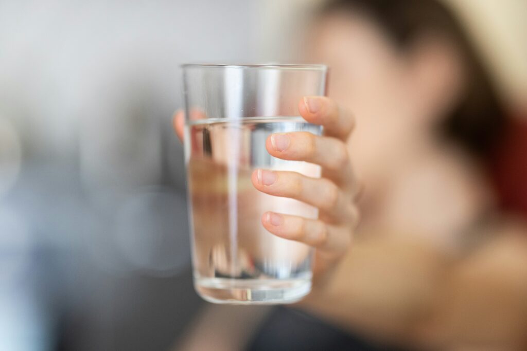 person holding out a glass of water