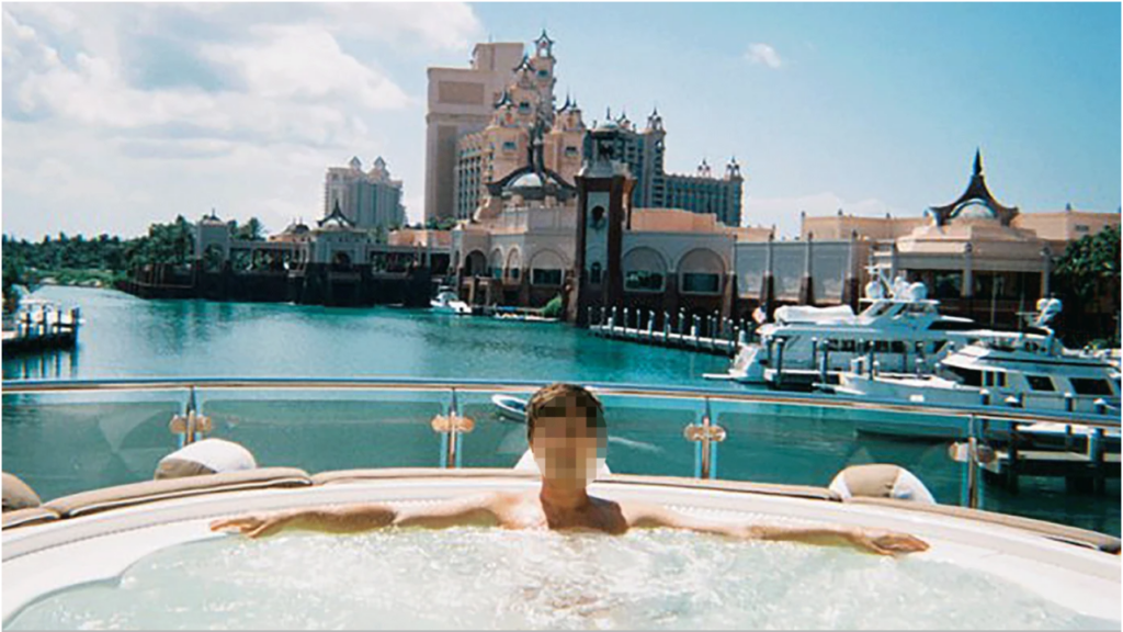 Man sits in hot tub on a yacht against a scenic background